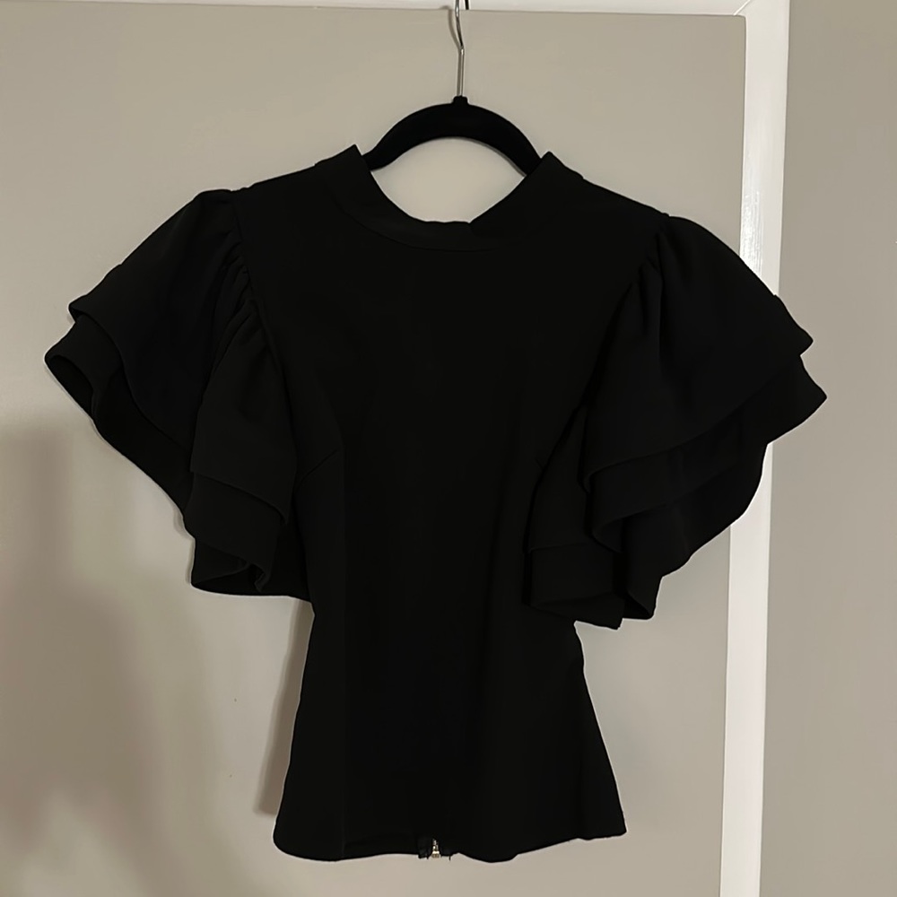 Beautiful black top. The back has a gold zipper and two buttons at the neck.